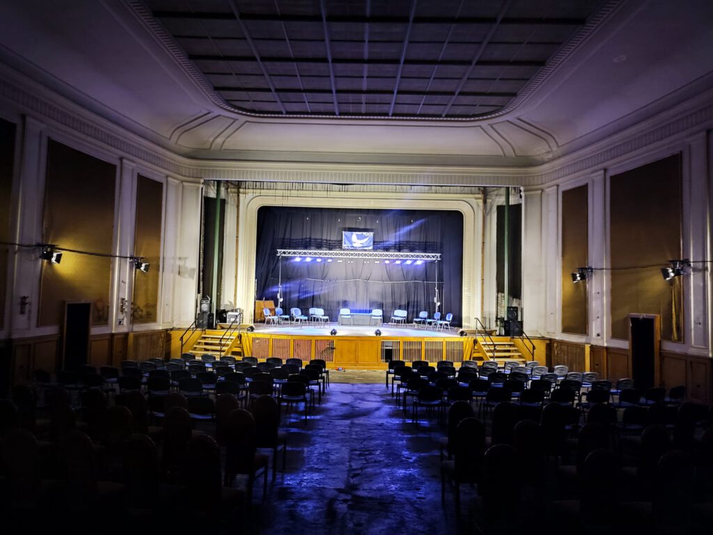 Blick aus dem Saal in Richtung Bühne mit Bühnenbeleuchtung